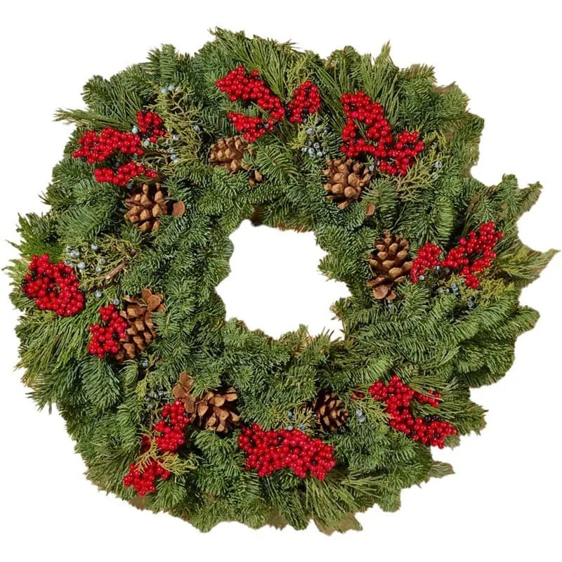 Festlich dekorierter Kranz mit Tannengrün, Beeren und Zapfen
