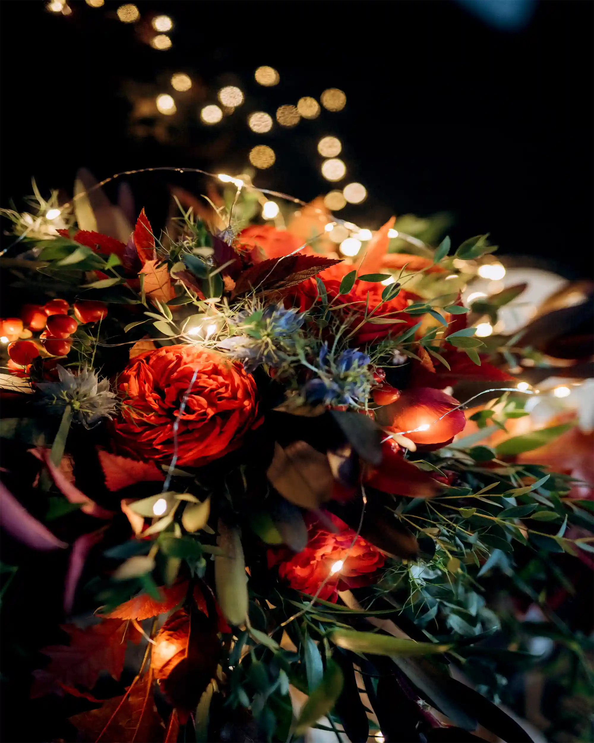 Bouquet of flowers with string lights against a dark background