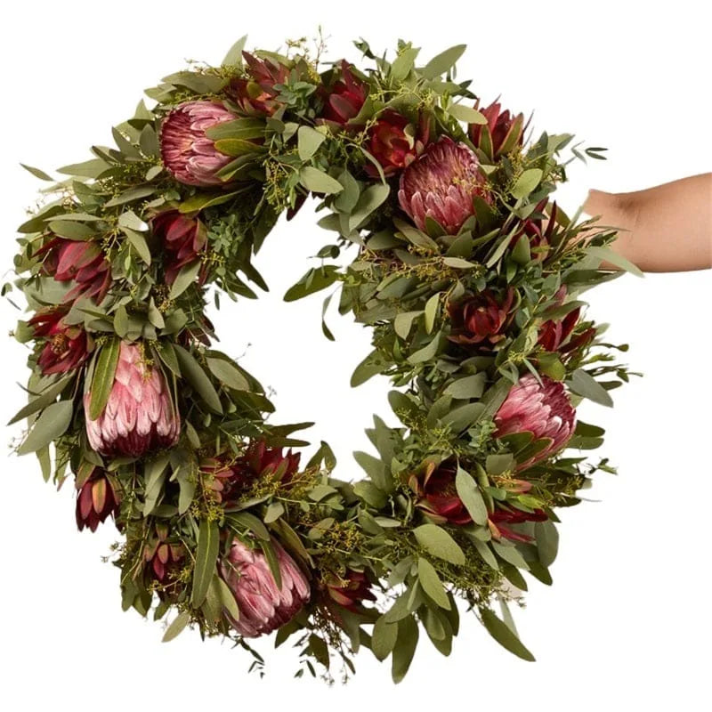 Kranz mit Protea-Blumen und grünen Blättern