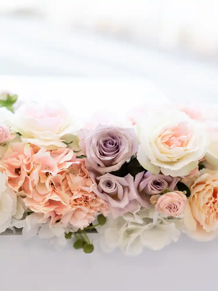 Arrangement of pink, purple, and white flowers on a light background