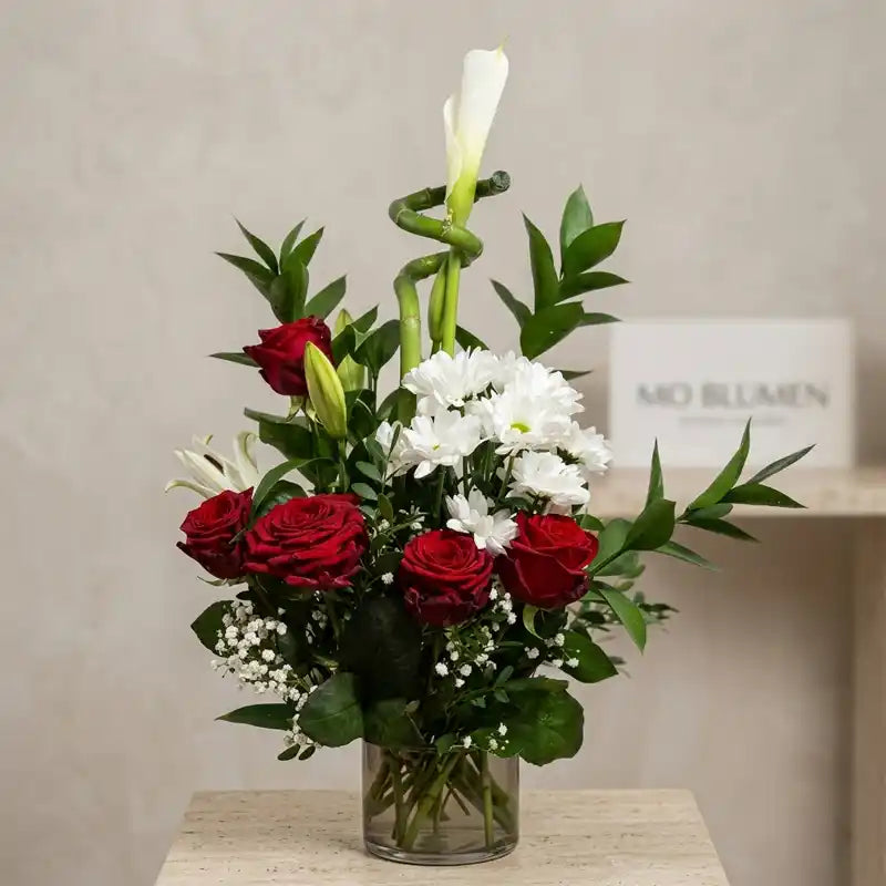 Muttertagsgesteck in Glasvase mit roten Rosen, weißen Chrysanthemen und Lilien – MO BLUMEN Wien
