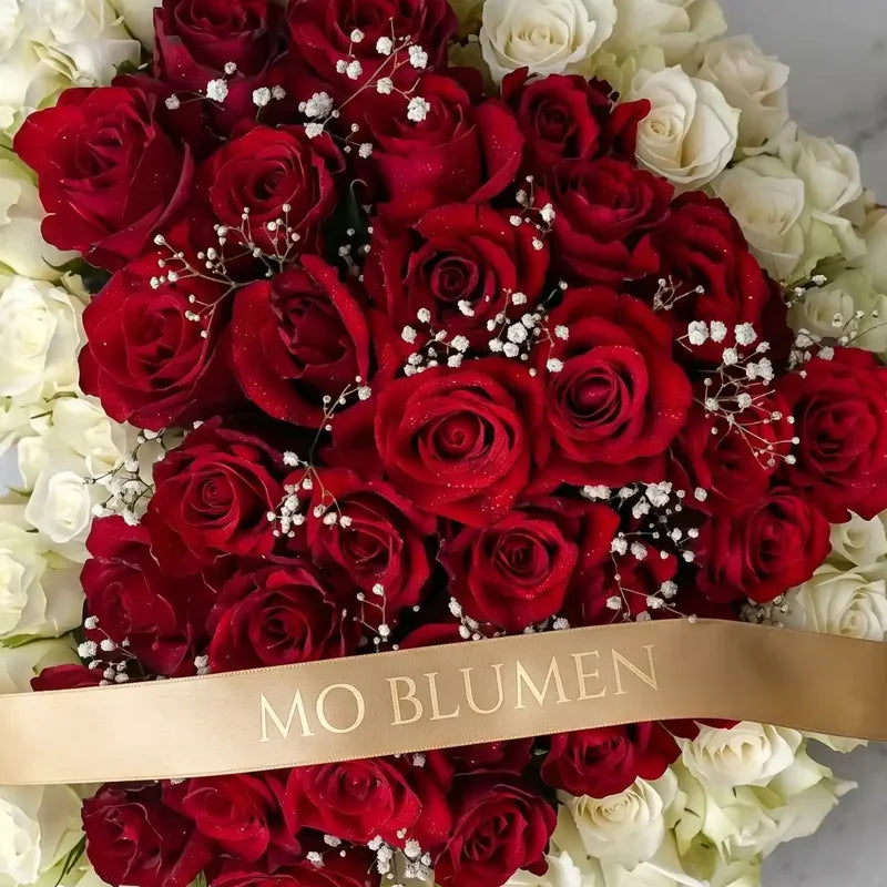 Rot-weißes Trauerherz aus Rosen im Biedermeier-Stil von MO BLUMEN, mit Schleierkraut und goldenem Band.