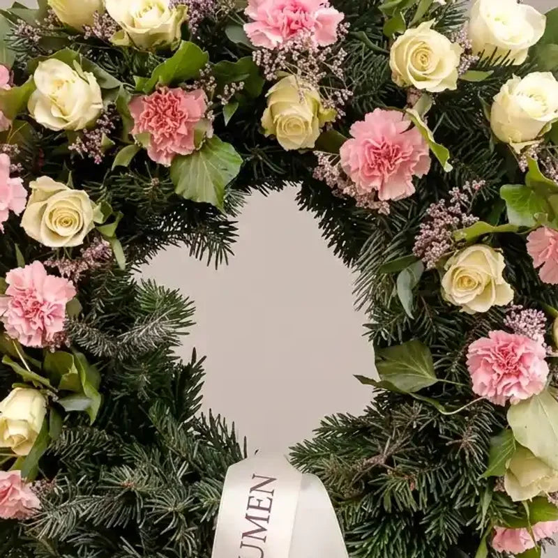 Trauerkranz mit rosa Rosen und Nelken von MO BLUMEN, aus Tannengrün mit weißem Band.